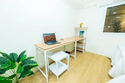 a desk with a laptop on it in a room at GL Sport Club Serviced Residence in Bangkok
