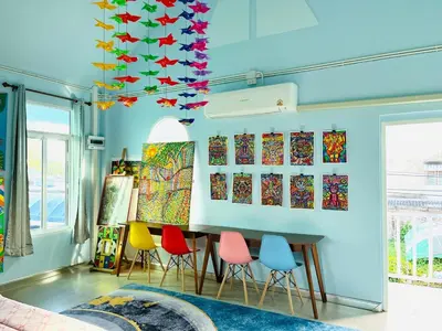 a room with colorful chairs and paintings on the wall at Setthisin Art Boutique House,Iconsiam,BTS Thonburi in Godown