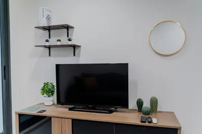 a flat screen tv sitting on top of a wooden entertainment center at 5 Star Sukhumvit Condo Infinity Pool Gym Sauna in Bangkok