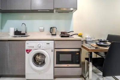 a kitchen with a washing machine and a sink at 5 Star Sukhumvit Condo Infinity Pool Gym Sauna in Bangkok