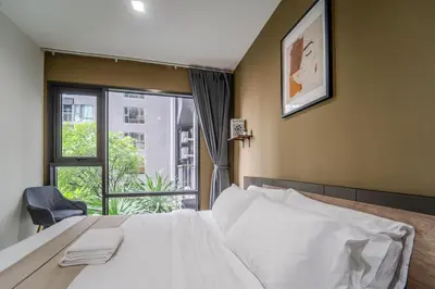 a bedroom with a white bed and a window at 5 Star Sukhumvit Condo Infinity Pool Gym Sauna in Bangkok