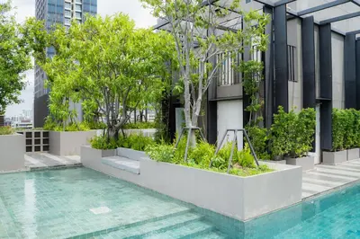 a swimming pool with trees and plants on a building at 5 star Luxurious 1BD apt King Bed Thong Lor in Bangkok