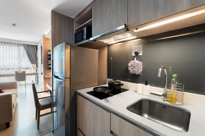 a kitchen with a sink and a stainless steel refrigerator at 5 star Luxurious 1BD apt King Bed Thong Lor in Bangkok
