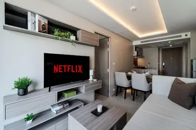 a living room with a couch and a tv and a table at Luxury 2BR with Sky Pool & Gym Near BTS Thong lo in Bangkok