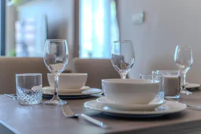 a table with plates and glasses on a table at Luxury 2BR with Sky Pool & Gym Near BTS Thong lo in Bangkok