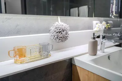 a bathroom counter with a sink and a mirror at Luxury 2BR with Sky Pool & Gym Near BTS Thong lo in Bangkok