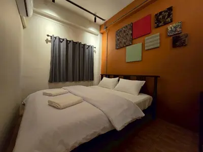 a bedroom with a large bed with white sheets at Lhong Krung Hostel in Bangkok