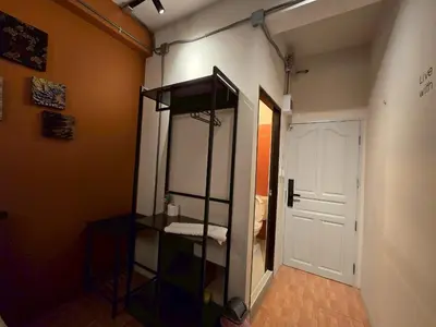 a room with a closet with a shelf and a door at Lhong Krung Hostel in Bangkok