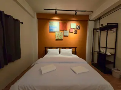 a bedroom with a large bed with two white pillows at Lhong Krung Hostel in Bangkok
