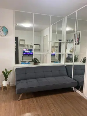 a living room with a gray couch in a room at Cozy Entire Apartment place in Ban Khlong Samrong