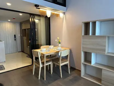a dining room with a wooden table and chairs at Standardized at City View Condo near BTS Ratchathewi in Bangkok