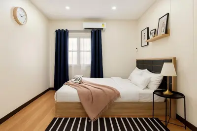 a bedroom with a bed and a clock on the wall at GM7 - Private House Downtown 2mins walk to metro in Bangkok