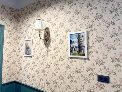 a room with flowers on the wall with two pictures at Nara Poshtel Sathorn in Bangkok