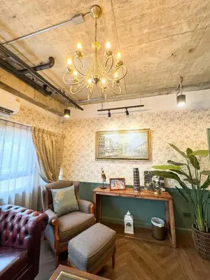 a living room with a couch and a chandelier at Nara Poshtel Sathorn in Bangkok