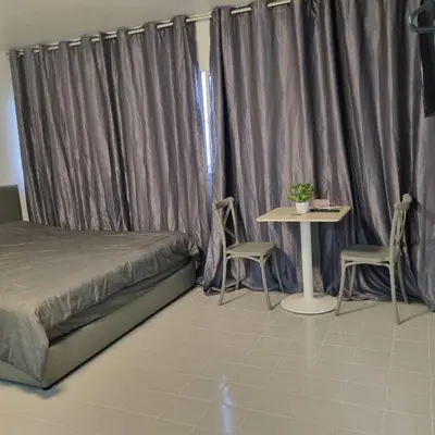 a bedroom with a bed and a table with chairs at Popular Muang Thong Condo, Building T9, Floor 8, Room 20 in Ban Bang Phang