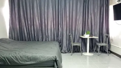 a bedroom with a bed and a table with chairs at Popular Muang Thong Condo, Building T9, Floor 8, Room 20 in Ban Bang Phang