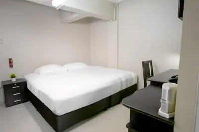 a bedroom with a bed and a desk with a computer at Annex Lumpini Bangkok in Bangkok