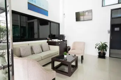a living room with a couch and a chair at Annex Lumpini Bangkok in Bangkok