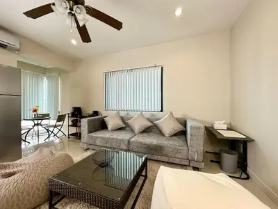 a living room with a couch and a ceiling fan at 2 mins to SRT I Urban Hideaway near Park in Bangkok