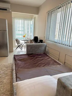a bedroom with a bed and a kitchen with a table at 2 mins to SRT I Urban Hideaway near Park in Bangkok