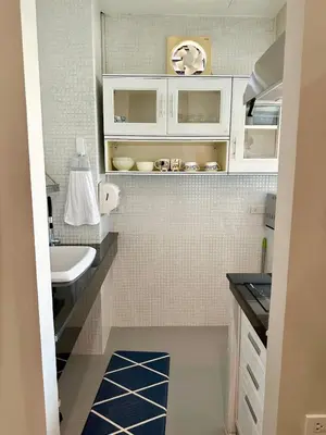 a small bathroom with white cabinets and a sink at 2 mins to SRT I Urban Hideaway near Park in Bangkok