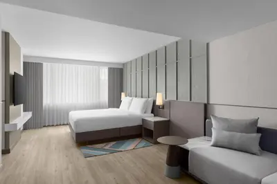 a hotel room with a bed and a couch at Courtyard by Marriott Bangkok Sukhumvit 20 in Bangkok