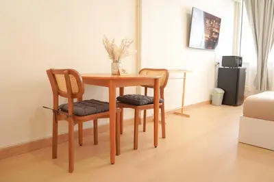 a table with two chairs and a table with a vase on it at Buddy House in Chinatown - Private Rooms Walk to MRT in Bangkok