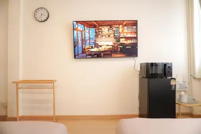a room with a refrigerator and a clock on the wall at Buddy House in Chinatown - Private Rooms Walk to MRT in Bangkok