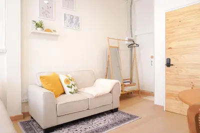 a white living room with a chair and a mirror at Buddy House in Chinatown - Private Rooms Walk to MRT in Bangkok