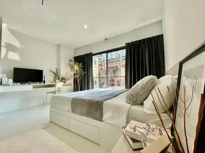 a white bedroom with a large bed and a window at Cozy stay! Near Chatuchak Market 814 in Bangkok