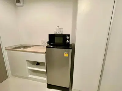 a small kitchen with a microwave on top of a refrigerator at Cozy stay! Near Chatuchak Market 814 in Bangkok