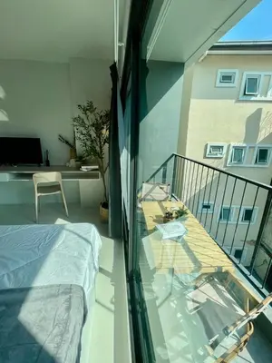 a room with a balcony with a bed and a table at Cozy Stay! Near Chatuchak Market 816 in Bangkok