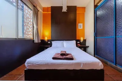 a bedroom with a bed with a robe on it at Diamond House Khaosan in Bangkok