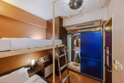 a room with two bunk beds and a bathroom at Diamond House Khaosan in Bangkok