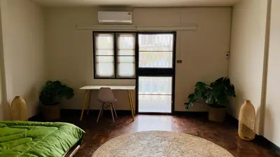a room with a bed and a table and windows at Creative Bangkok Balcony in Sathani Bang Khen