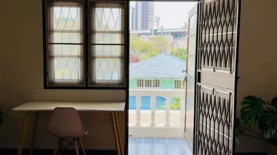 a door with a window and a chair in a room at Creative Bangkok Balcony in Sathani Bang Khen