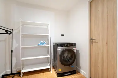 a washing machine in a room with a shelf at Townhouse in Khet Phayathai - Ari in Bangkok