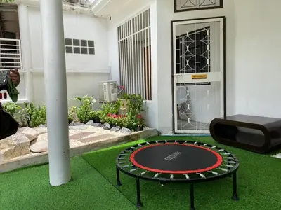 a round table in the middle of a room with grass at Cheap house 7min next to BTS Kasetsart , 5 bedroom in Ban Yang
