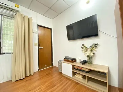 a living room with a flat screen tv on a wall at Cheap house 7min next to BTS Kasetsart , 5 bedroom in Ban Yang