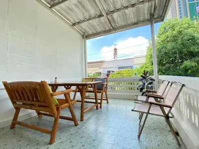 a patio with a table and chairs and a window at Cheap house 7min next to BTS Kasetsart , 5 bedroom in Ban Yang