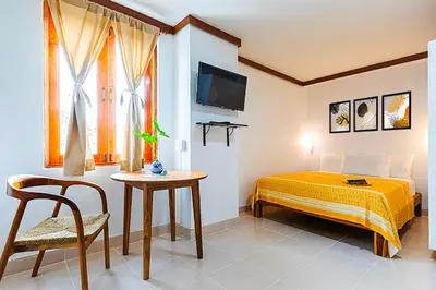 a bedroom with a bed and a table and a tv at Dancenter Howard Square Boutique Hotel in Bangkok