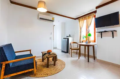 a living room with a blue chair and a table at Dancenter Howard Square Boutique Hotel in Bangkok