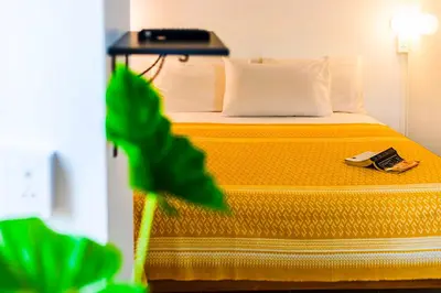 a hotel room with a bed with a phone on it at Dancenter Howard Square Boutique Hotel in Bangkok