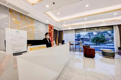 a woman wearing a face mask in a lobby at Dancenter Bangkok Travellers Hotel in Bangkok