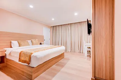 a hotel room with a large bed and a television at Dancenter Bangkok Travellers Hotel in Bangkok