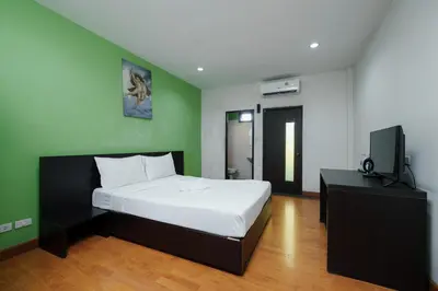 a bedroom with a bed and a television in it at Dancenter Khaosan Park Hotel in Bangkok