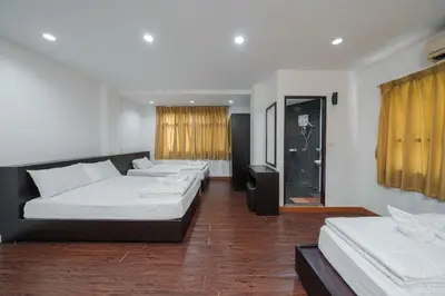 a hotel room with three beds and a window at Dancenter Khaosan Park Hotel in Bangkok