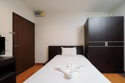 a bedroom with a bed with a flower on it at Dancenter Khaosan Park Hotel in Bangkok