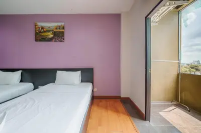 a small room with two beds and a shower at Dancenter Khaosan Park Hotel in Bangkok