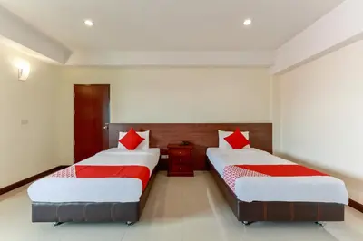 a bedroom with two beds with red pillows at Dancenter VResotel in Bangkok
